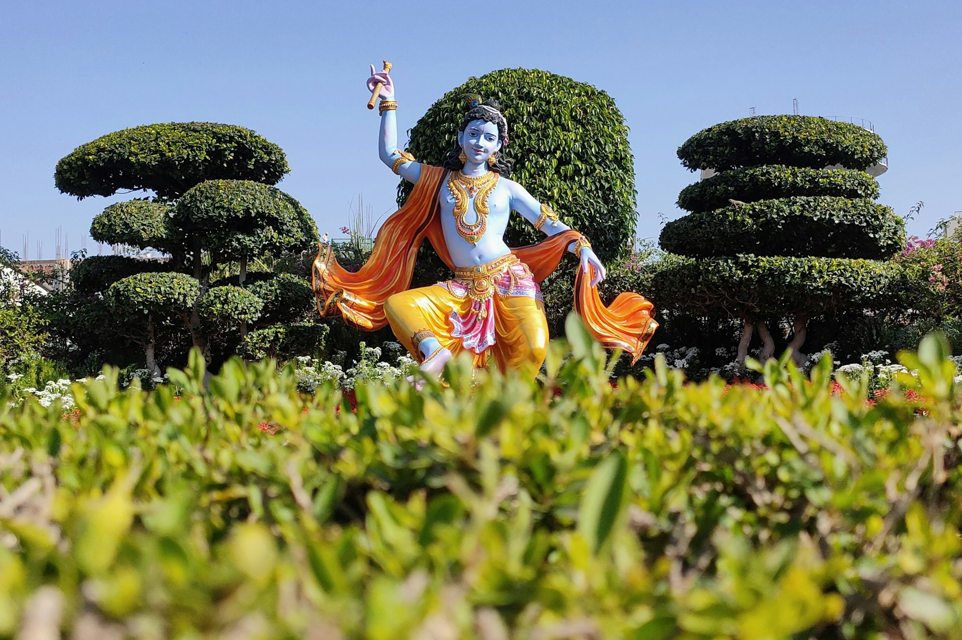 a statue of a hindu god in a garden