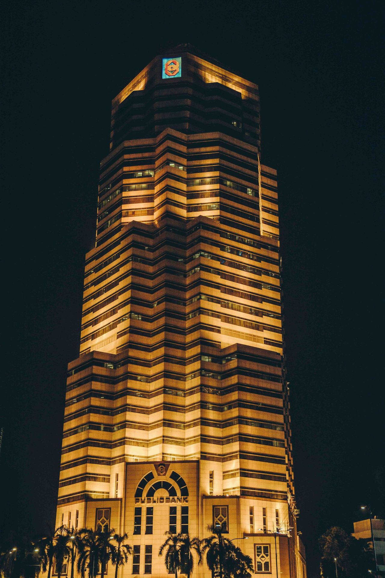 Public bank tower illuminated at night.