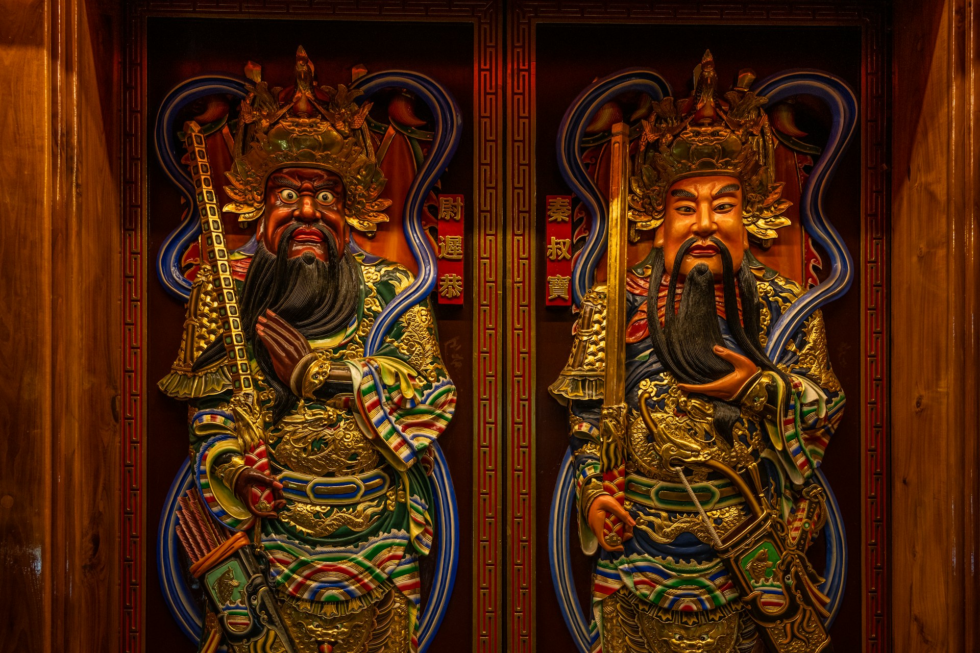 Two statues of a man and a woman in front of a wooden door