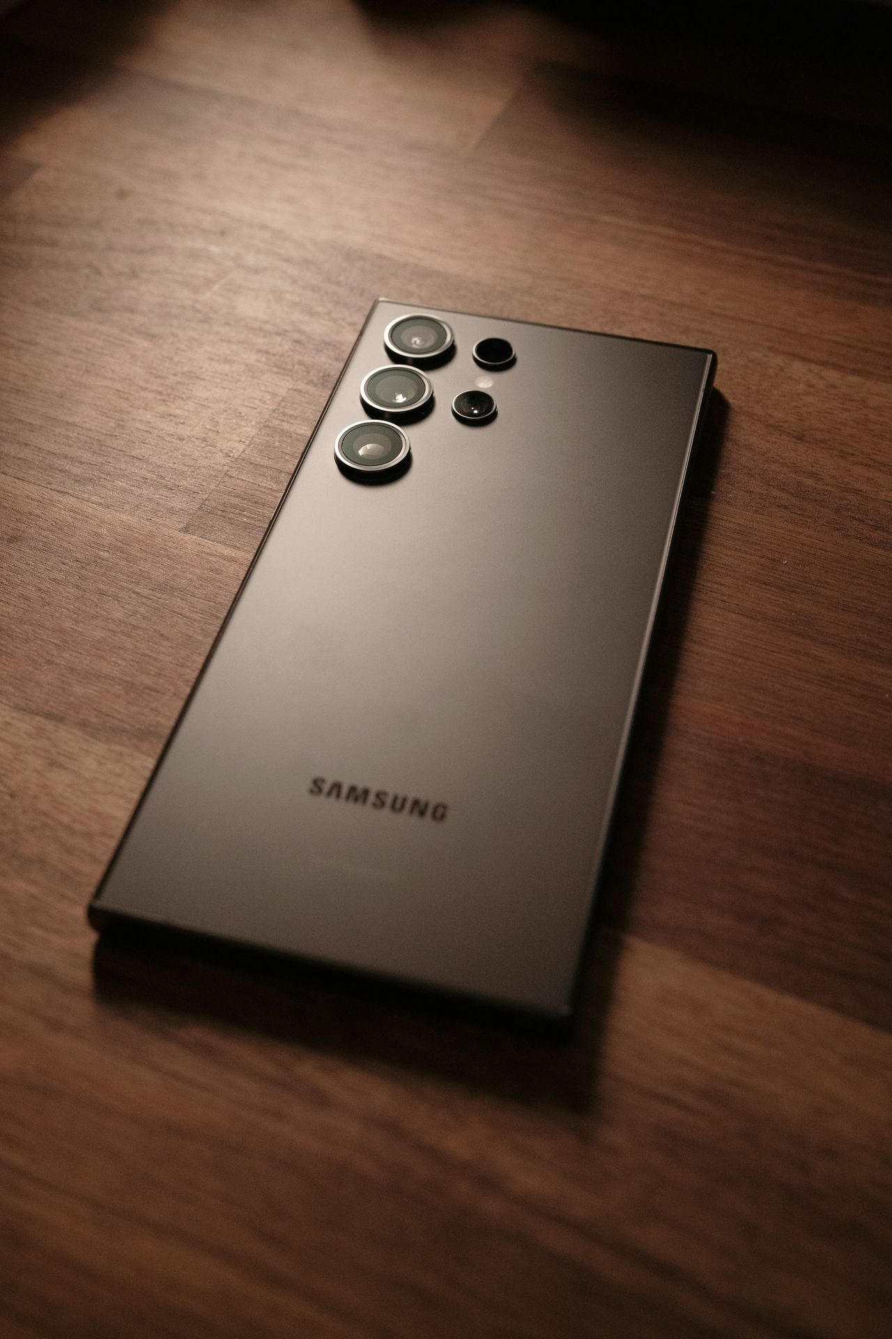 a close up of a cell phone on a wooden surface