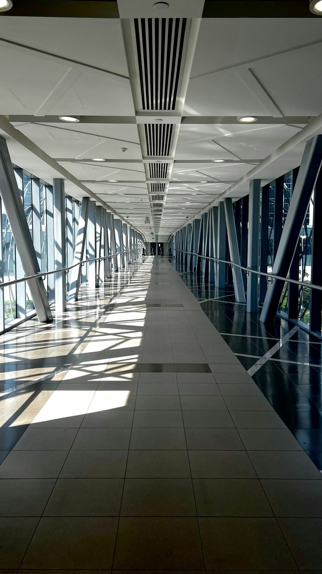 a long hallway with lots of windows and a clock on the wall