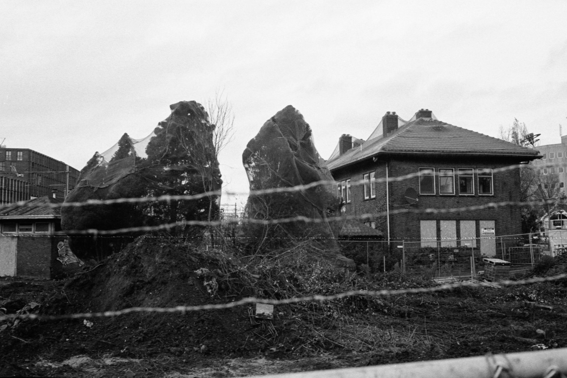 grayscale photo of house near rock formation