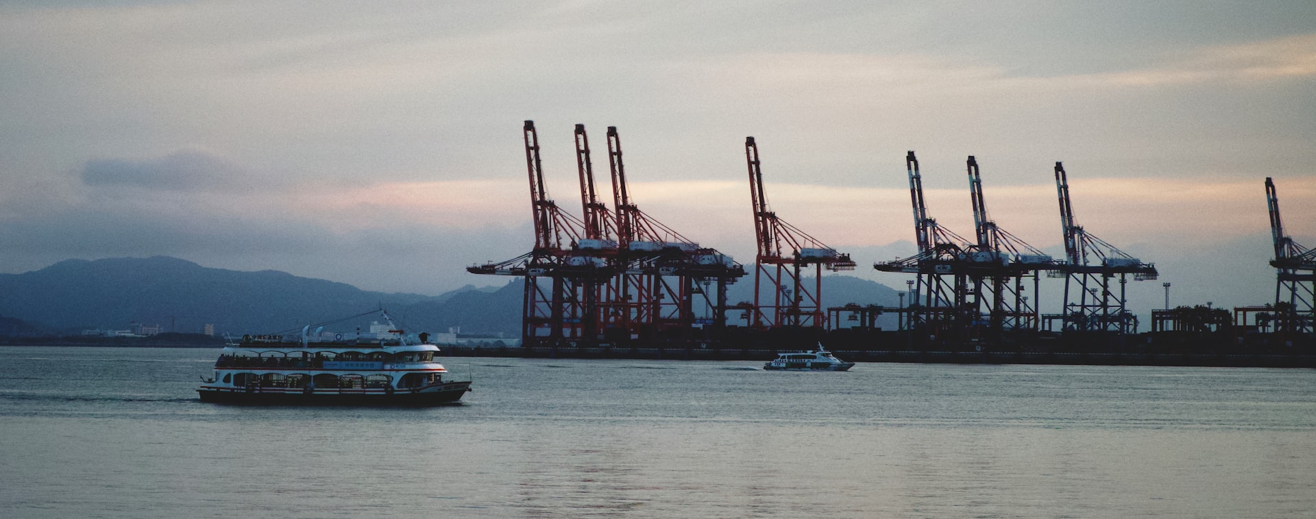 a boat in a body of water with a lot of cranes in the background