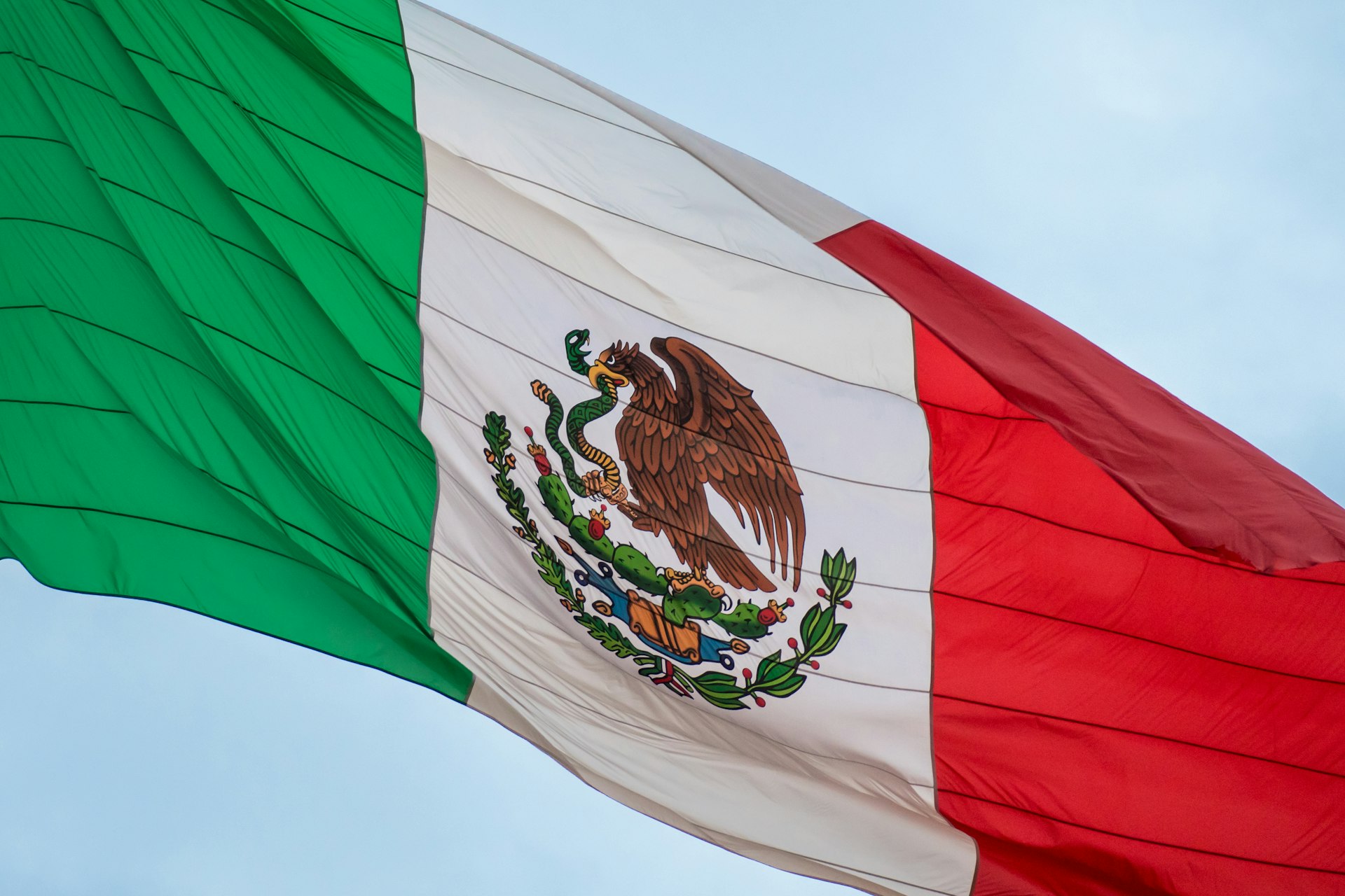 The mexican flag is flying high in the sky