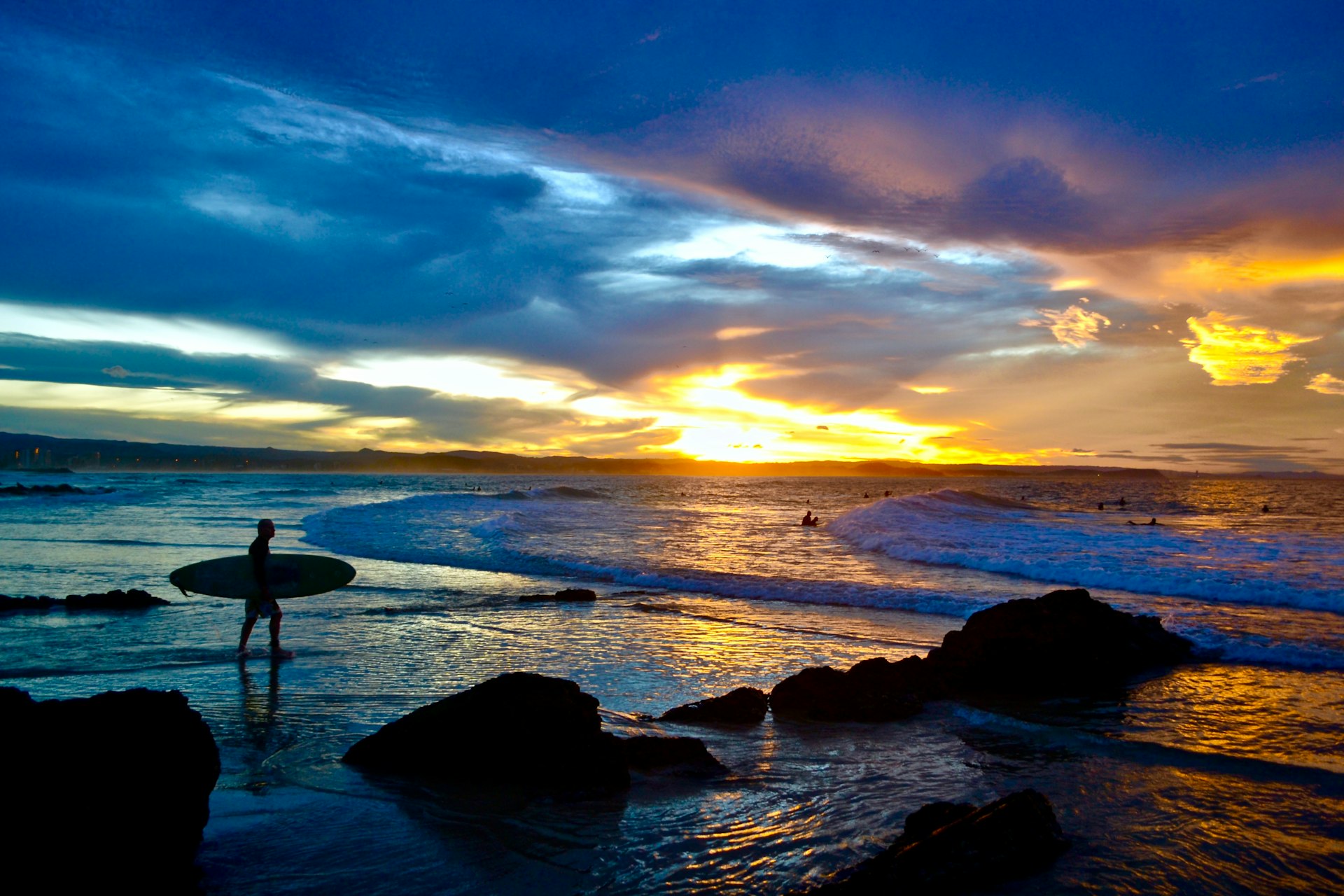 silhouette of 2 people standing on seashore during sunset