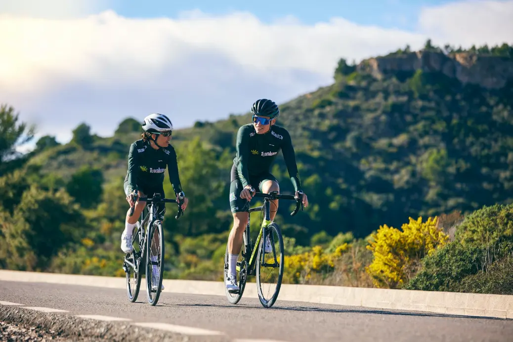 a couple of people riding bikes down a road