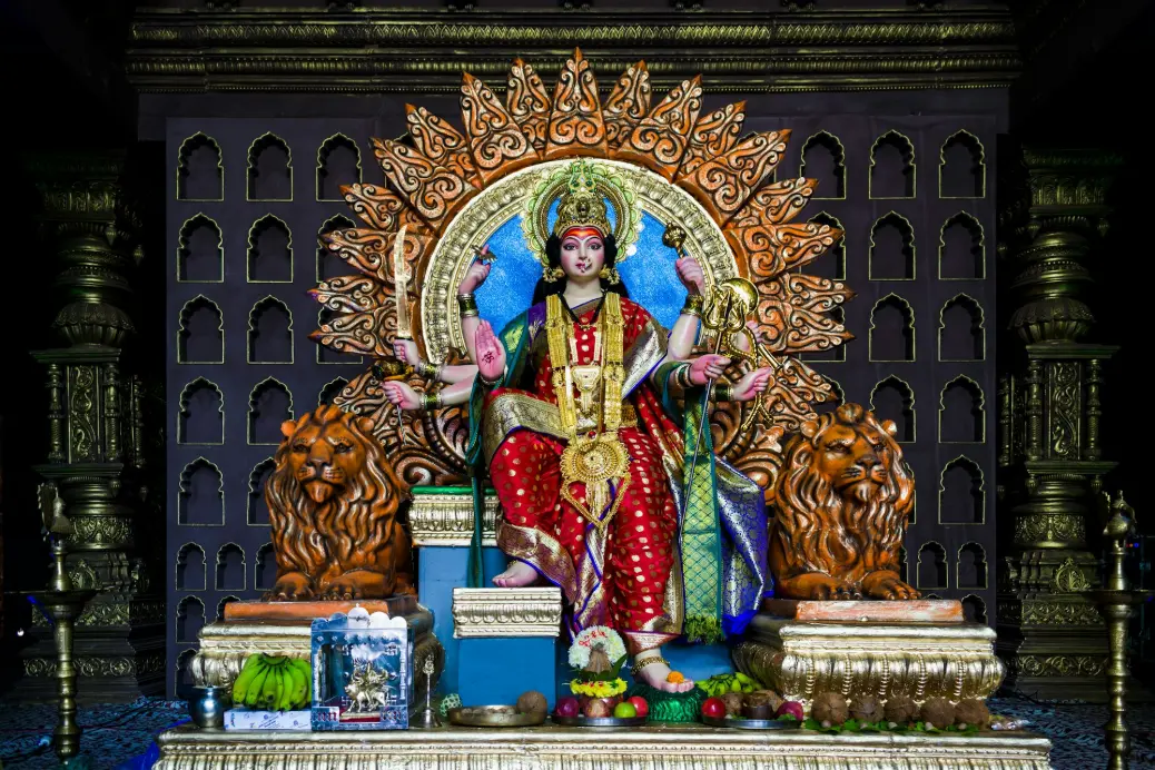 hindu deity statue on gold and gold armchair