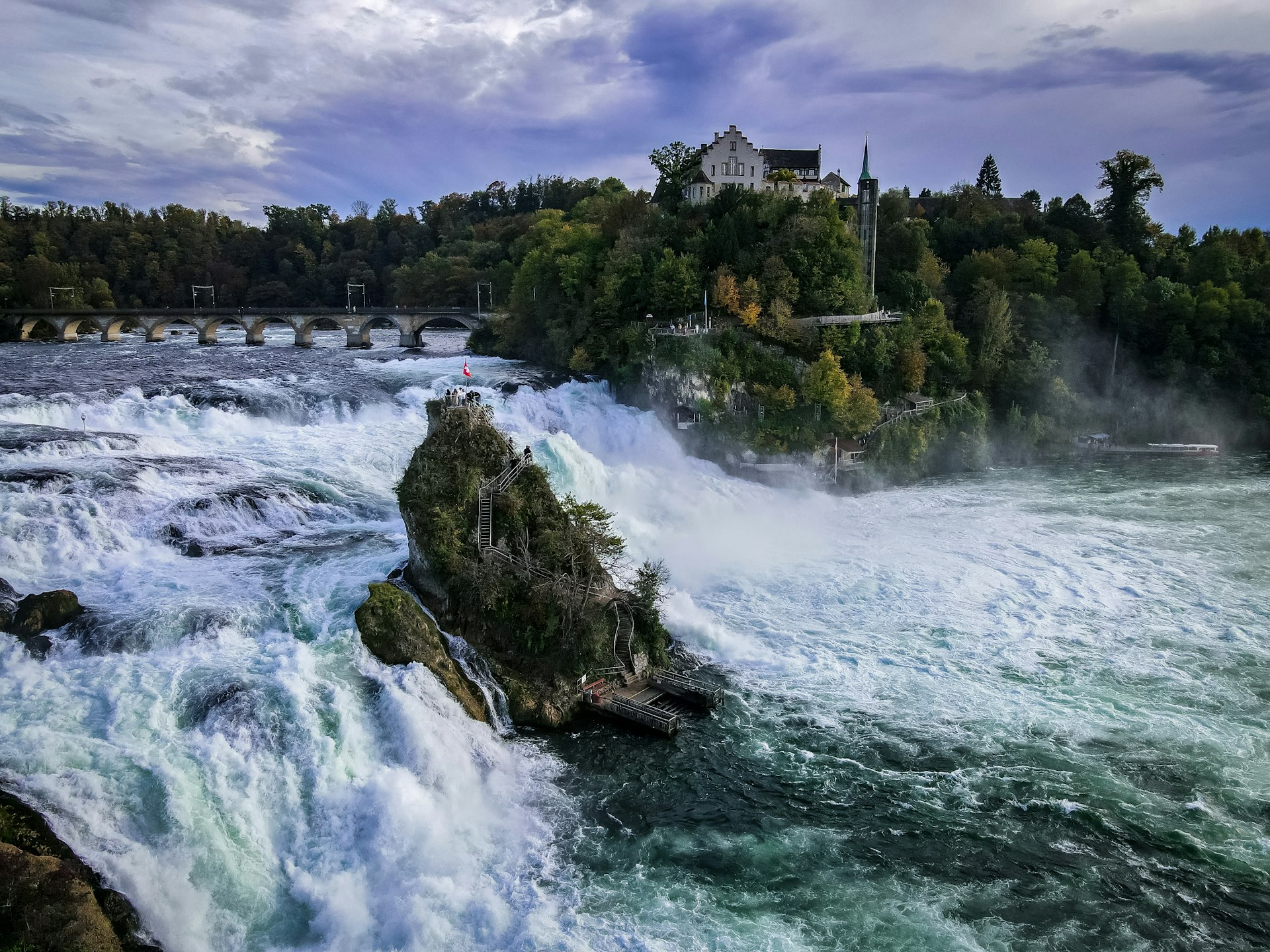 A large waterfall with a house on top of it
