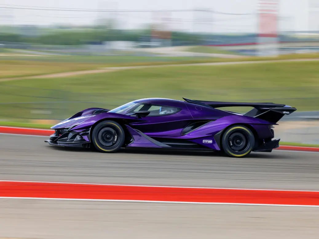A purple sports car driving down a race track