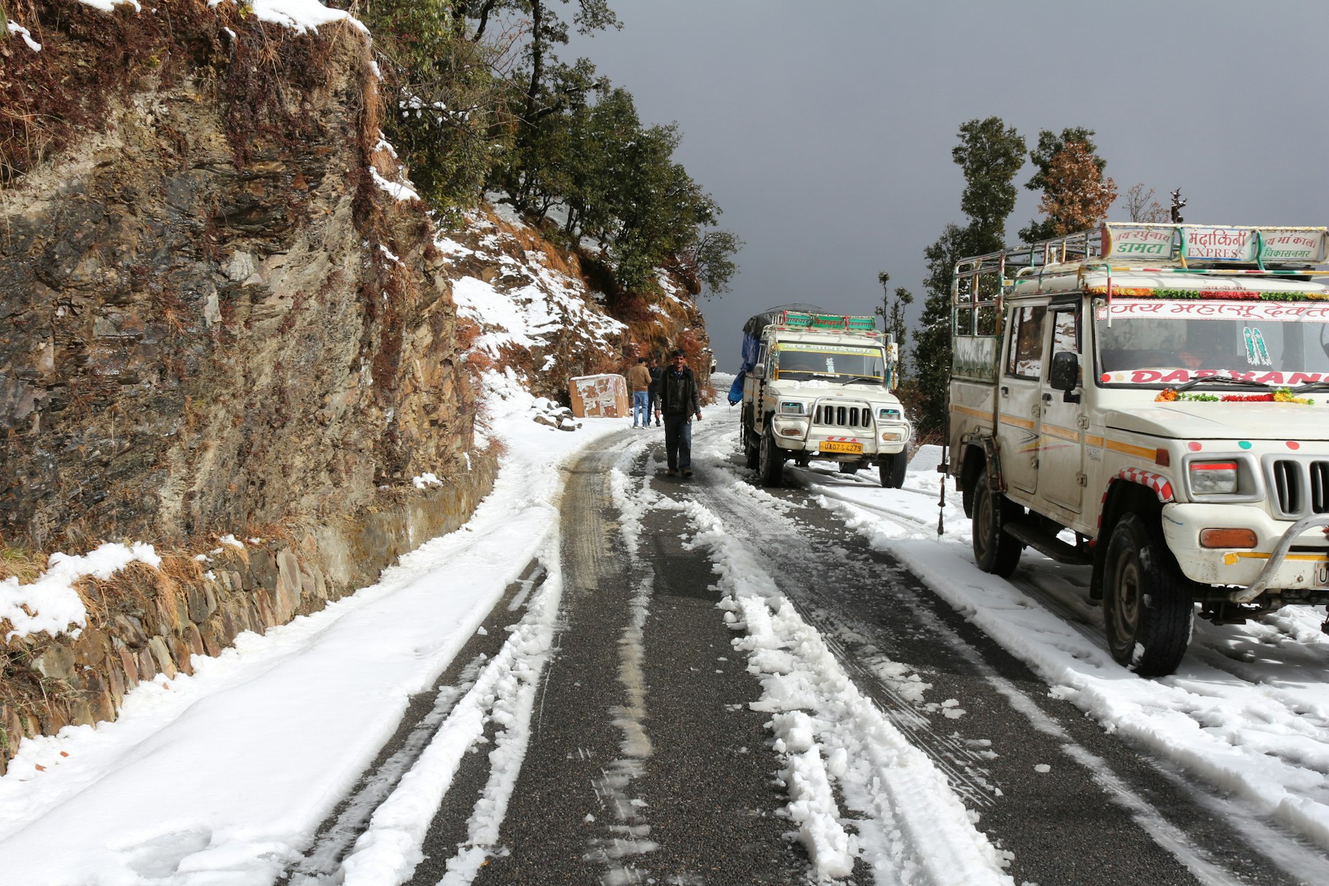 blue van on road covered with snow during daytime
