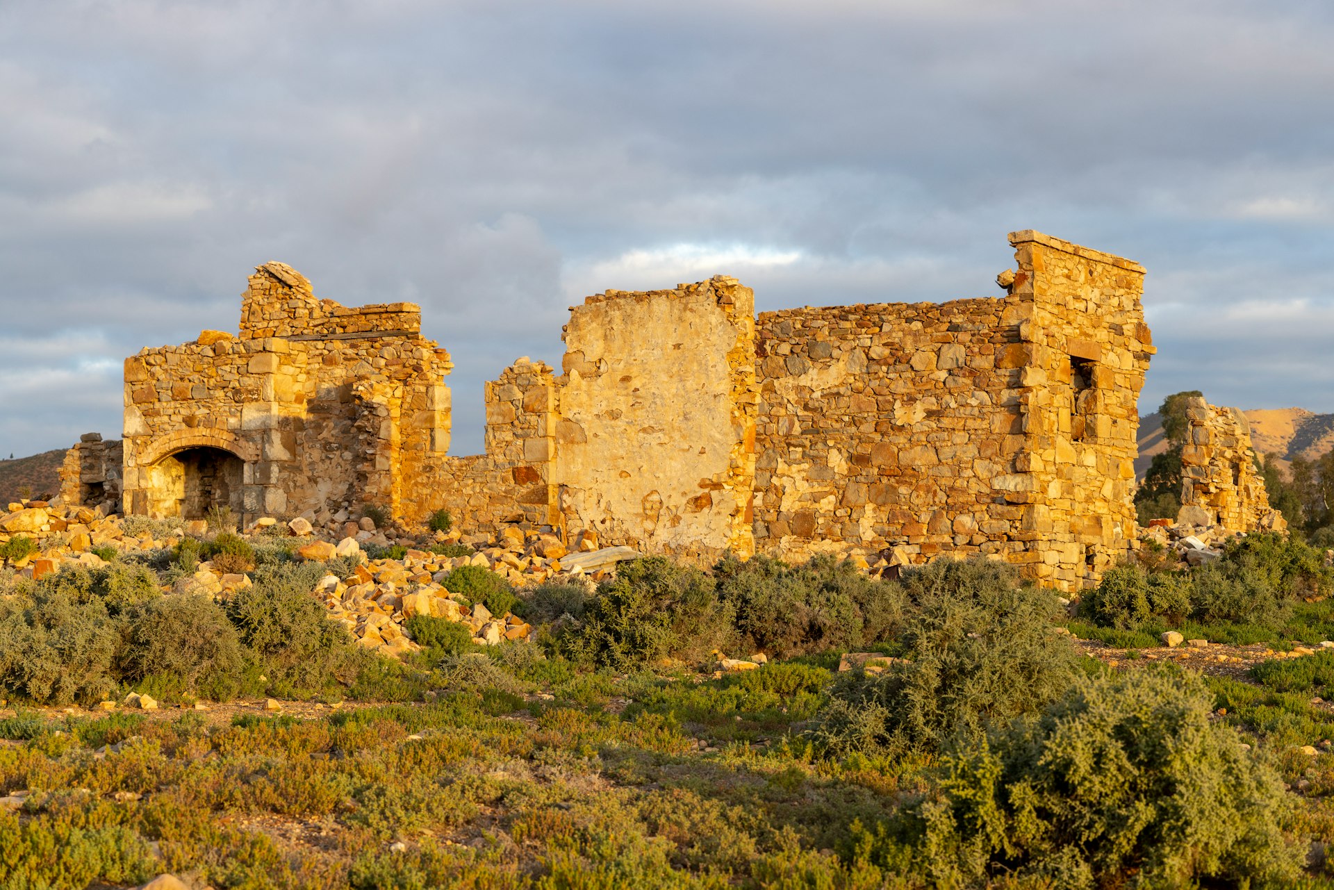 a stone building sitting on top of a lush green hillside