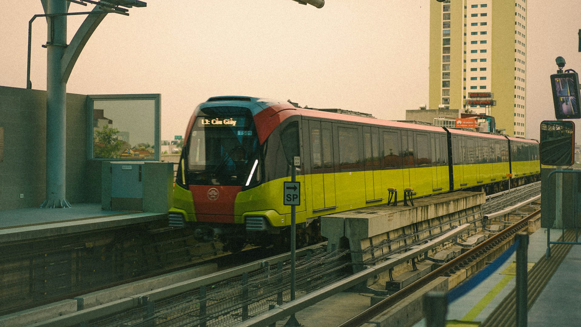 A yellow and red train traveling down train tracks