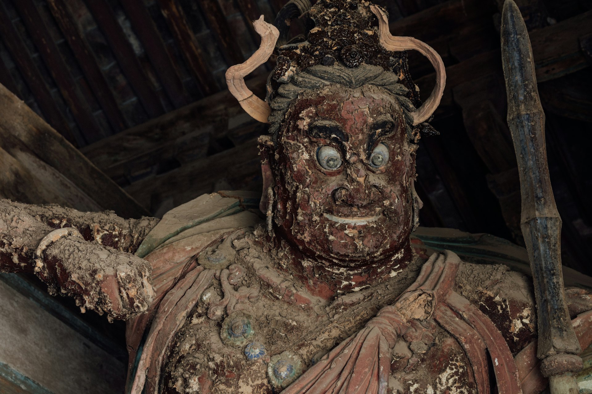 a close up of a statue of a person with a horned head