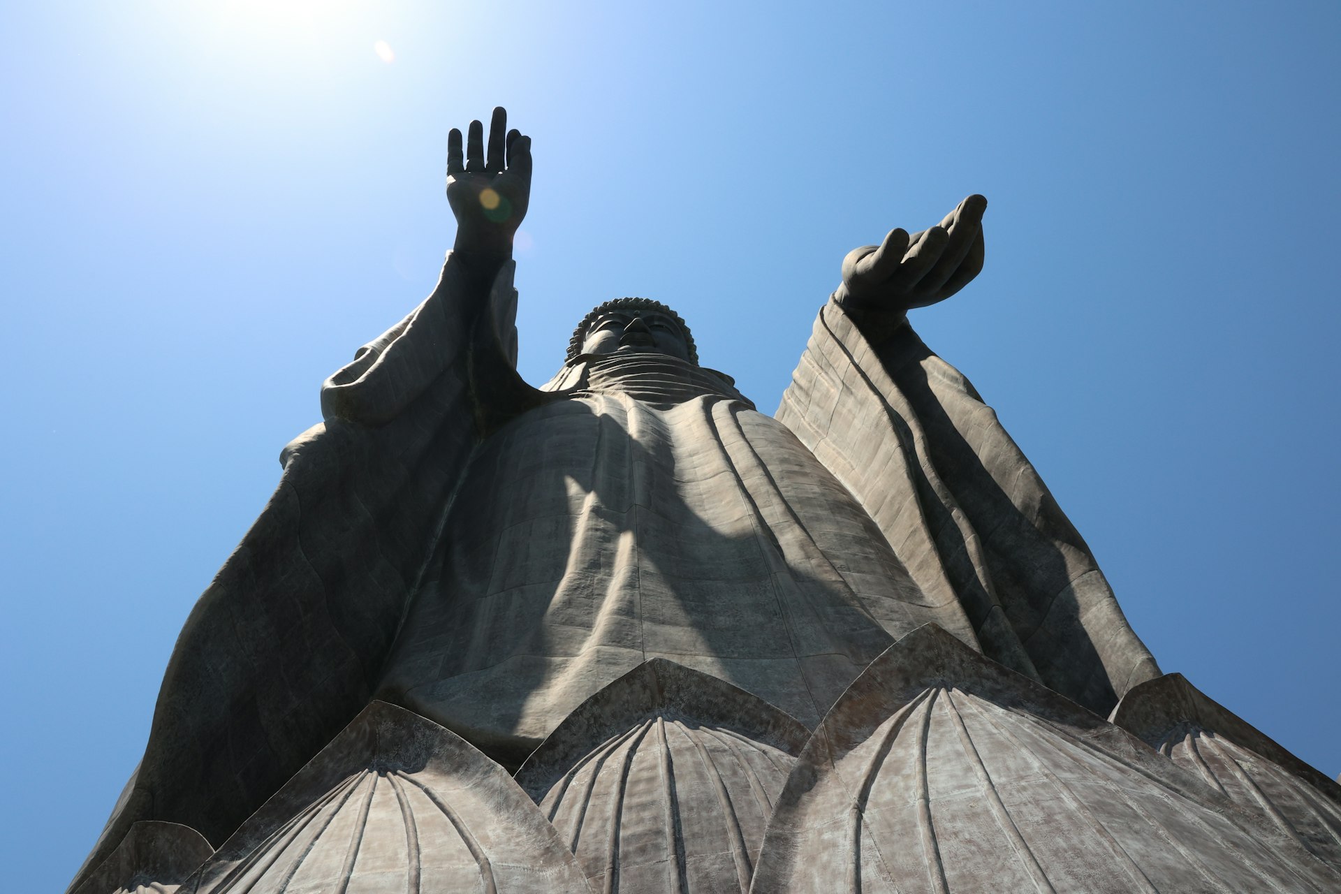 a statue of a person reaching up into the sky
