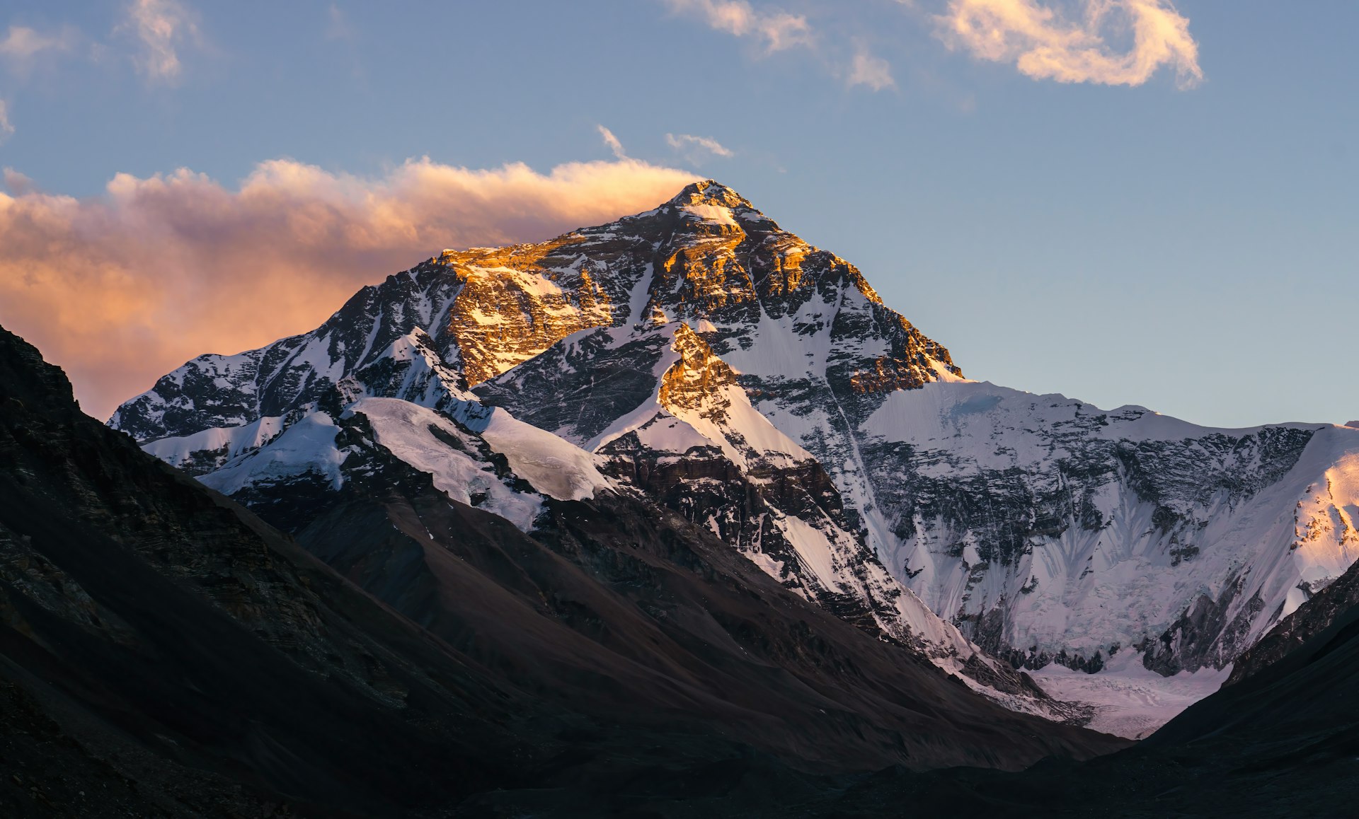 a snow covered mountain with clouds in the sky
