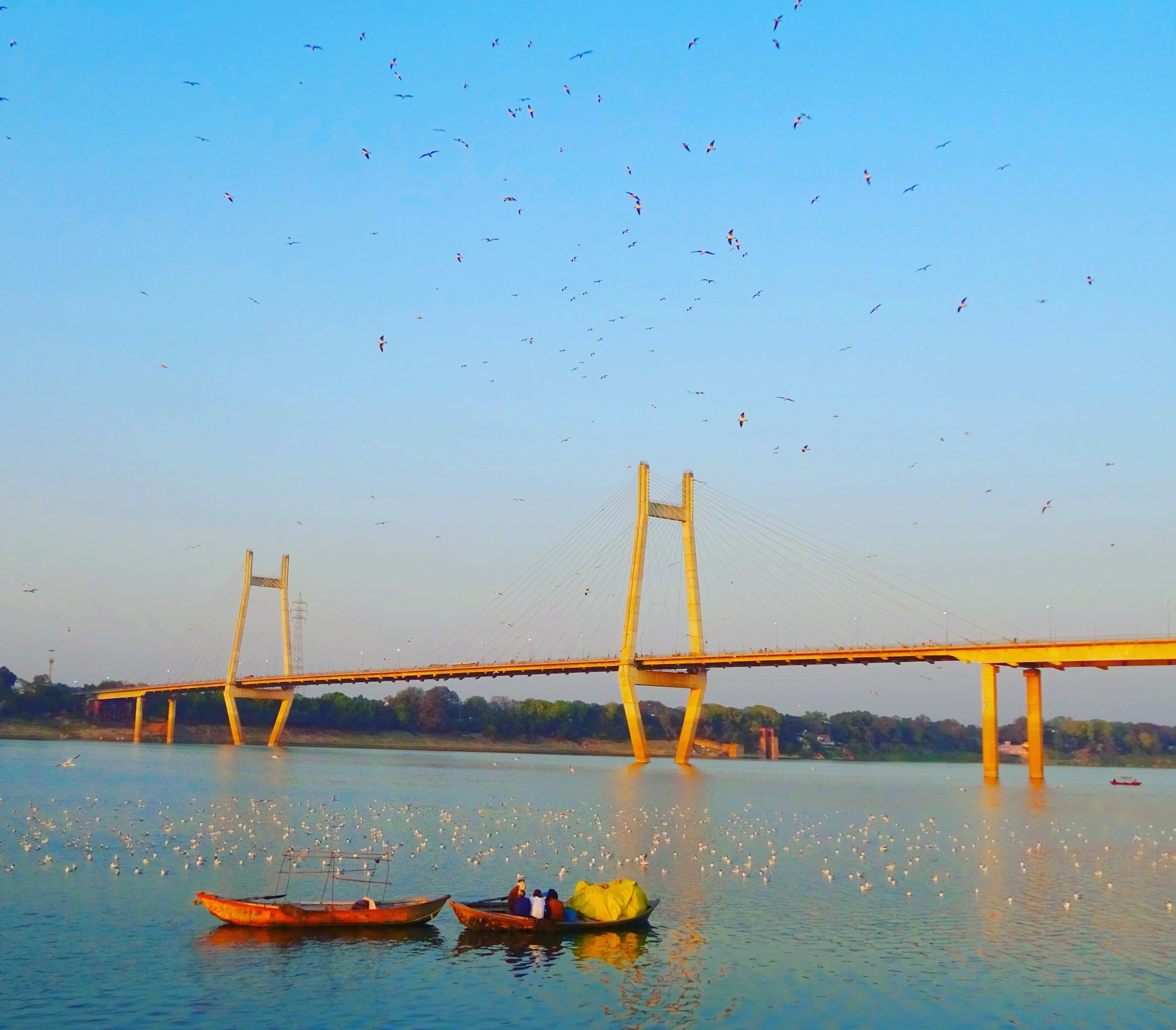 a group of boats floating on top of a lake next to a bridge