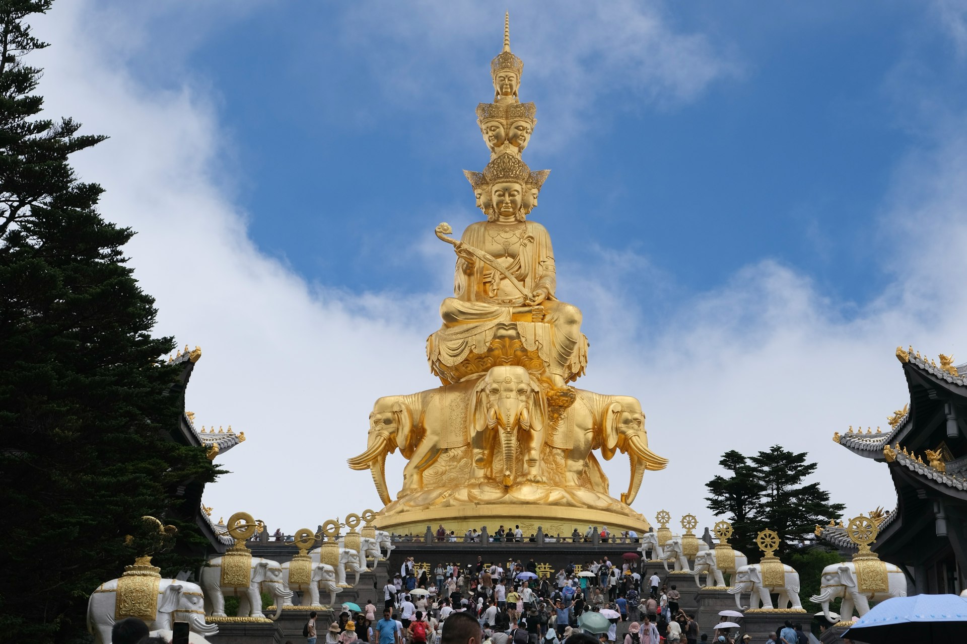 A group of people standing in front of a golden statue