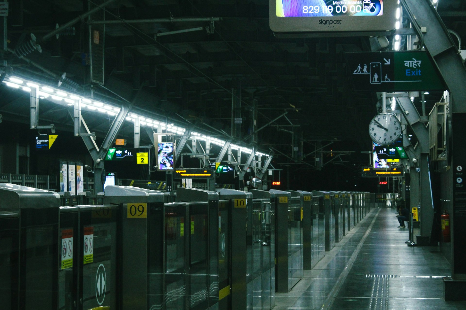 A train station with a lot of lights on the ceiling