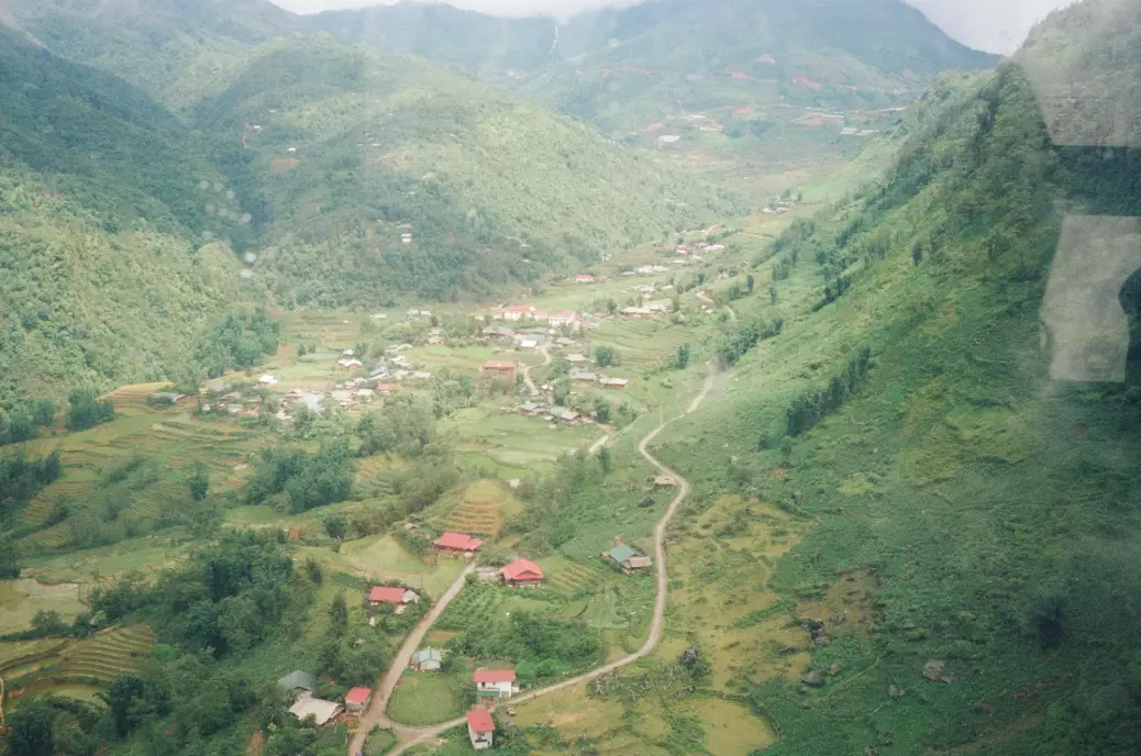 A valley town nestled between lush, green mountains.