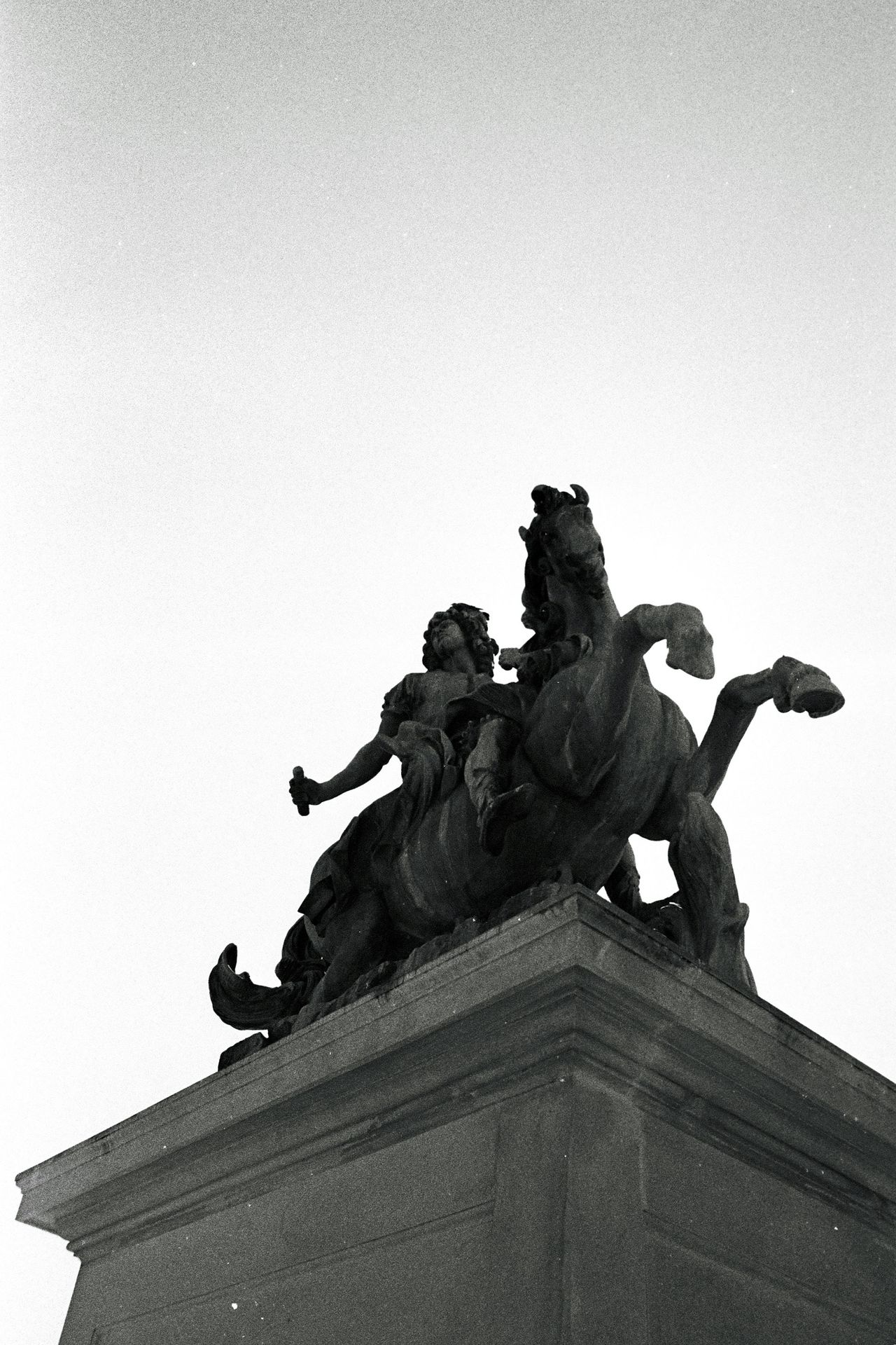 a black and white photo of a statue of a man on a horse