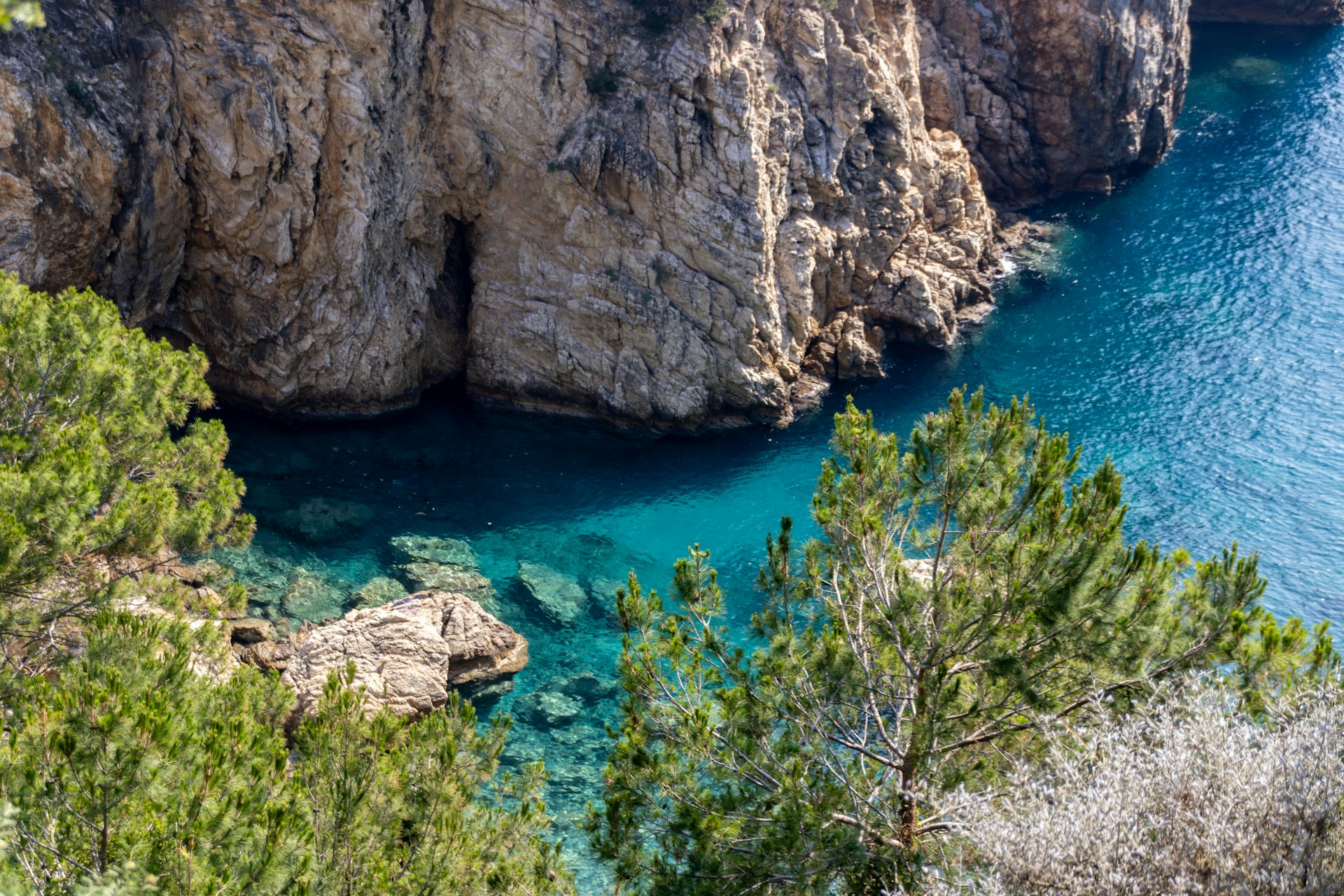 Rocky cliffs and turquoise water meet.