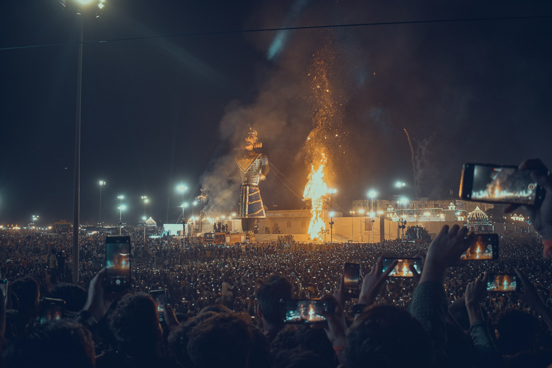 a large crowd of people watching a stage with a large fire