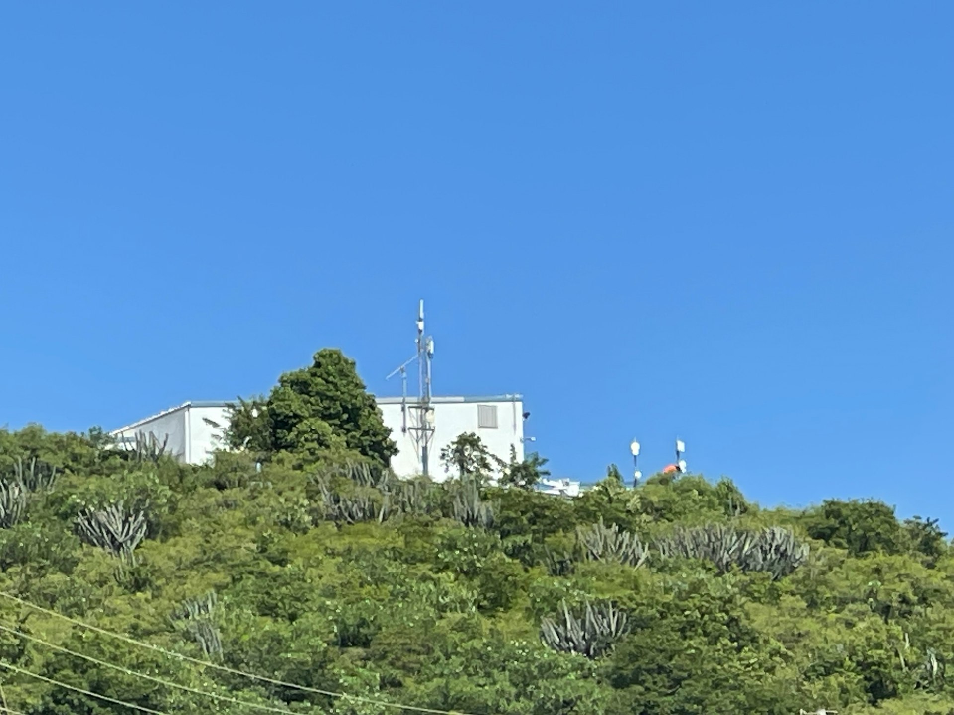 A white building on top of a green hill
