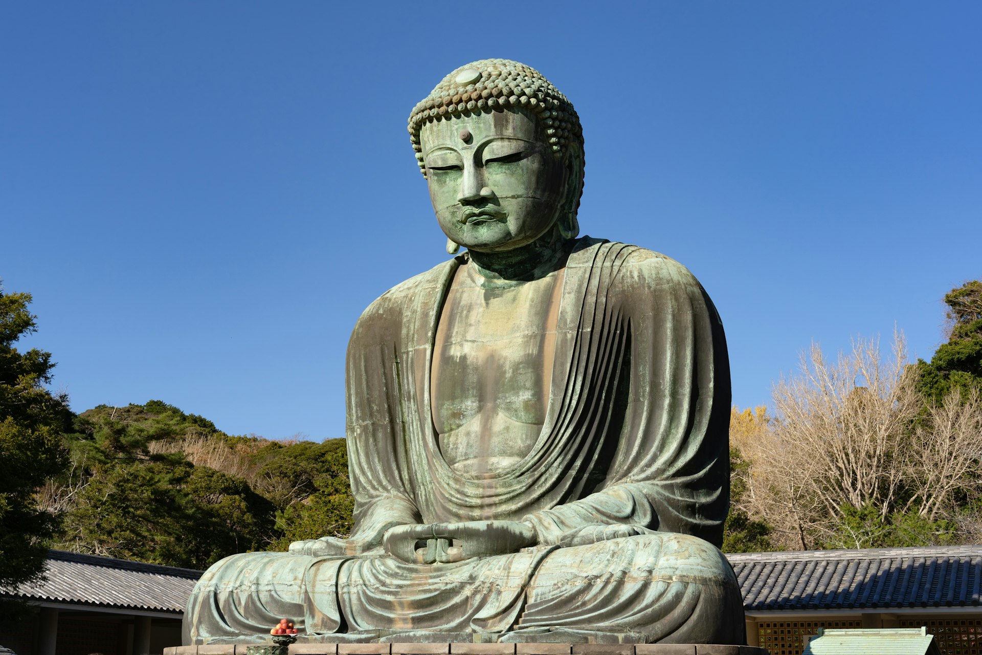 a large statue of a buddha sitting in front of a building