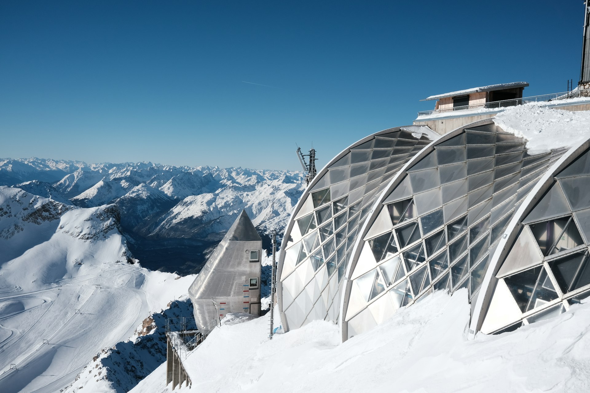 A ski lodge on a snowy mountain with mountains in the background