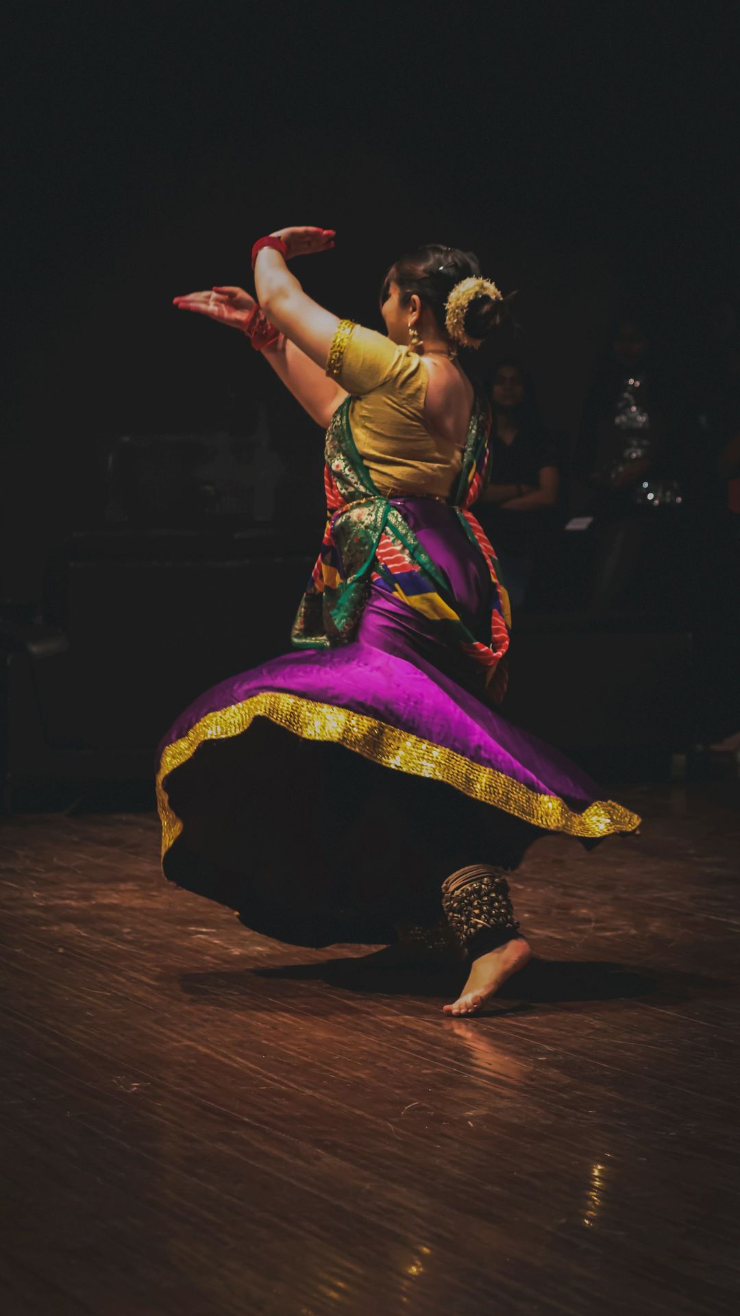 a woman is dancing on a wooden floor