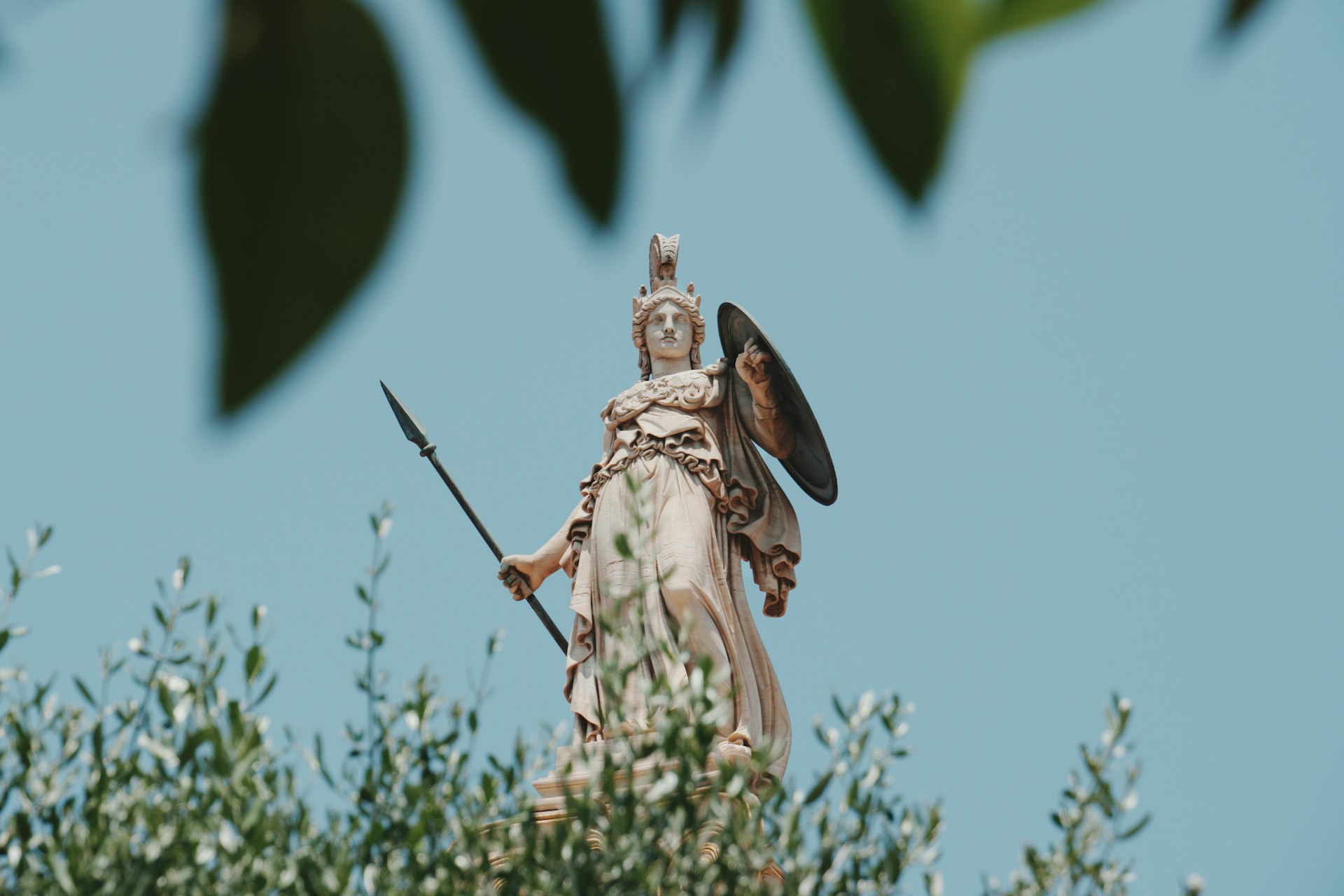 Statue of athena towers above the foliage.